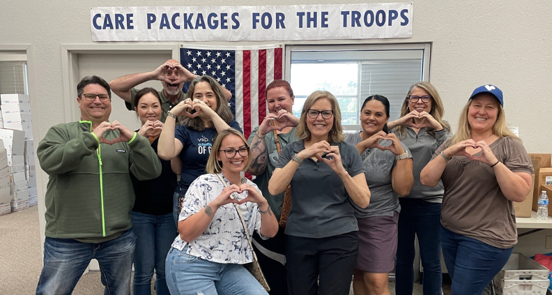 Members of the Military, Veterans, and Families Business Resource Group (BRG) shows heart hands while participating in an event to support our troops.