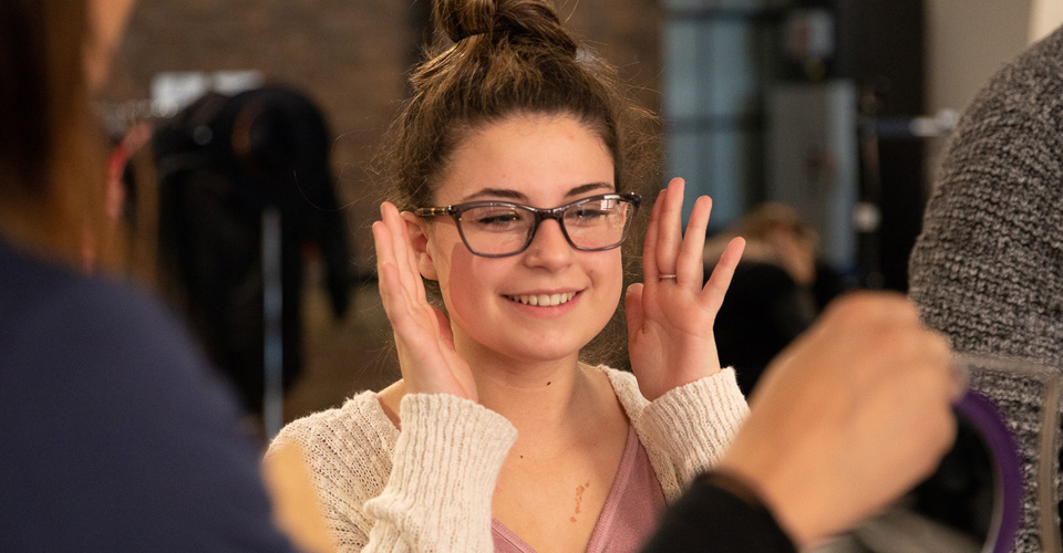 A girl looking in a mirror with glasses on